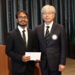 米山奨学生 ハサン モハッマド タンヴィル君（左）に奨学金を授与する 八木基之会長。