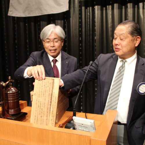 創立当時、豊橋ロータリークラブより寄贈された記念の鐘。 左より八木基之会長、佐藤元英会員。